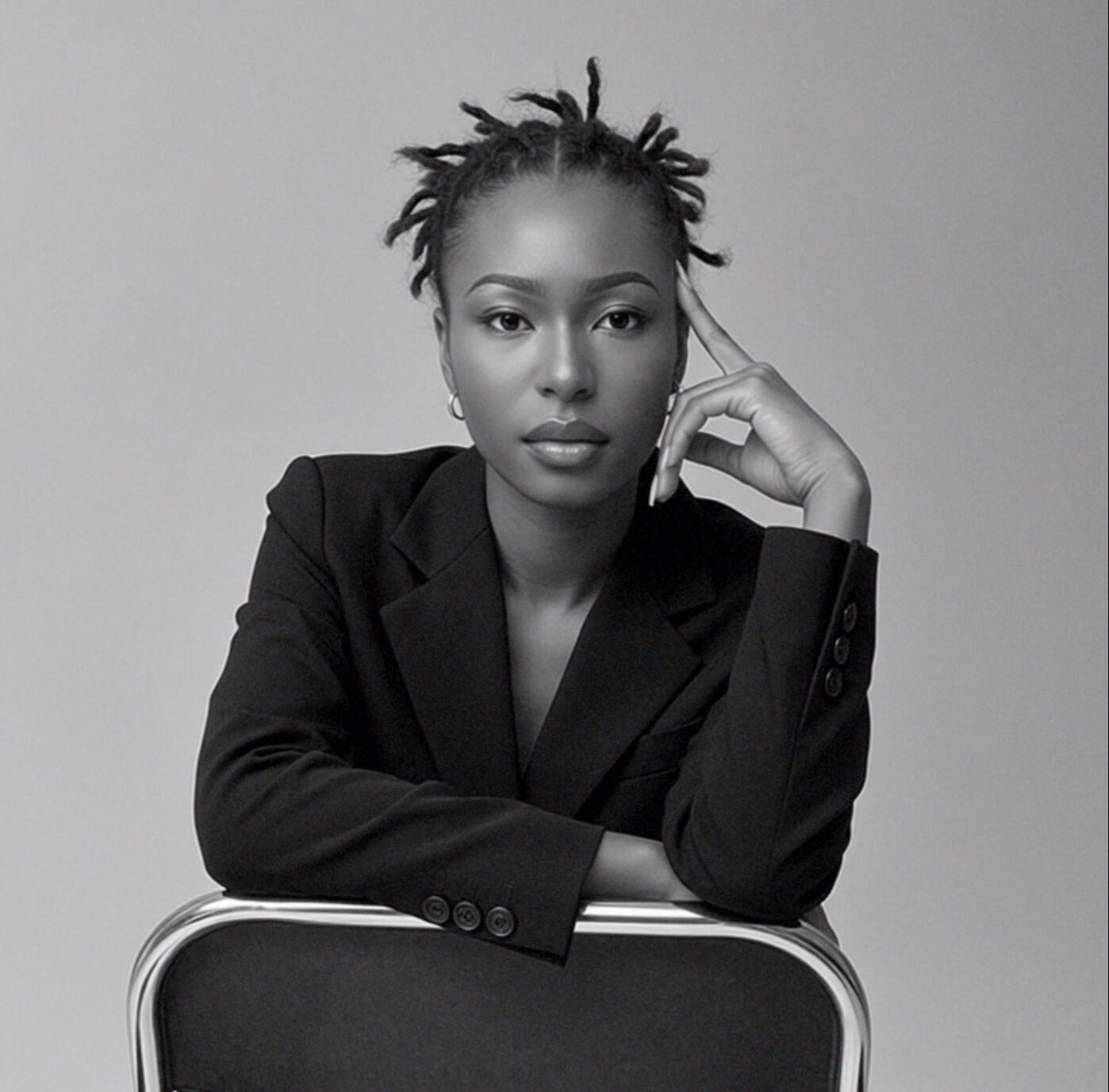 Black and white portrait of Lehbie Rae, French illustrator and visual storyteller, seated in a black suit.